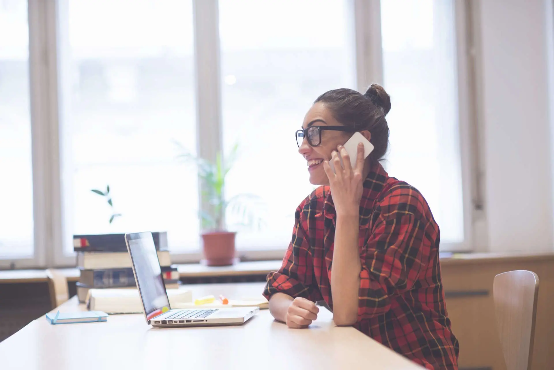Eventmanagerin am Telefon im hellen Büro